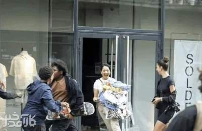 عکس پربازدید از اعتراضات فرانسه و خوشحالی یک دختر بعد از سرقت لباس‌های فروشگاه برند مشهور زارا